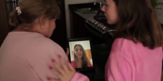 拉丁祖母和外孙女在家里用数码平板电脑进行视频通话
