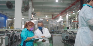 亚洲中国工厂检验员和领班在生产线上与生产线工人的工作背景讨论矿泉水质量和生产进度