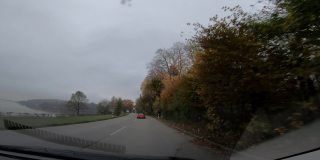 司机在高速公路上的视角，奥地利欧洲公路旅行视野从车内驾驶与自然森林景观树木和山脉