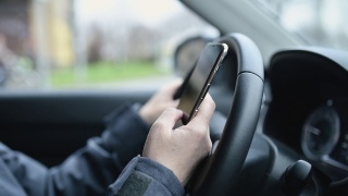 一名女子在停车场的车里用智能手机发送短信视频素材模板下载
