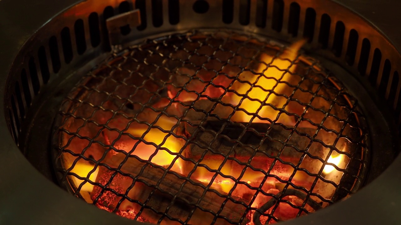 烧烤炉内的火木炭烧烤炉，用于烧烤食物，并带烟罩。它通常用于烧烤餐厅。可以在亚洲食物中找到，比如韩国、日本和中国餐馆。木炭炉子火焰