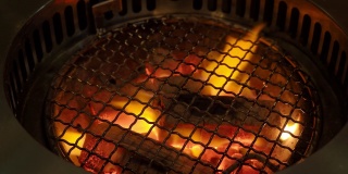烧烤炉内的火木炭烧烤炉，用于烧烤食物，并带烟罩。它通常用于烧烤餐厅。可以在亚洲食物中找到，比如韩国、日本和中国餐馆。木炭炉子火焰