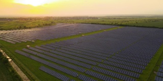 大型可持续发电厂的鸟瞰图，夜间有一排排的太阳能光伏电池板，用于生产清洁的电能。零排放的可再生电力概念