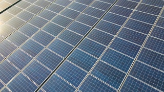 蓝色光伏太阳能电池板表面鸟瞰图，安装在建筑屋顶，产生清洁的生态电力。生产可再生能源概念。视频素材模板下载