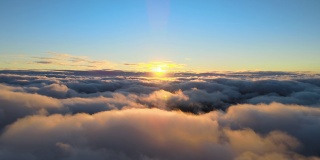从高空俯瞰，浓密蓬松的积云在傍晚飞舞。从飞机窗口看到的令人惊叹的日落