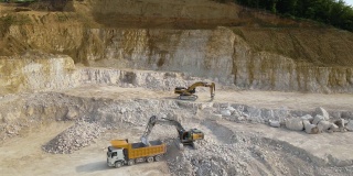 露天开采建筑砂石材料用挖掘机和自卸卡车。