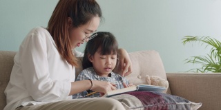 亚洲家庭与女儿做家庭作业与母亲在家里的帮助