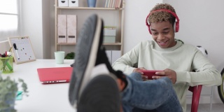微笑上瘾的年轻拉丁青少年男子玩手机应用程序的视频游戏
