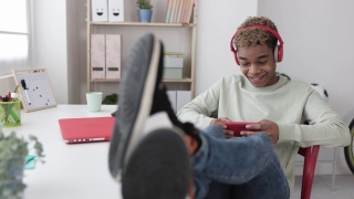 微笑上瘾的年轻拉丁青少年男子玩手机应用程序的视频游戏视频素材模板下载