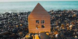 海边卵石海滩上的硬纸板房子的特写。抵押与租赁概念