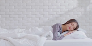 美丽迷人的亚洲女人睡觉和甜蜜的梦躺在床上舒适的卧室早上感觉如此放松和舒适。健康年轻女性在家就寝。医疗保健的概念