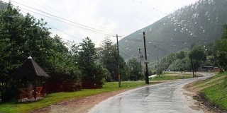挡风玻璃上的雨刷将水清洗干净，司机可以看到从父亲那里穿过的山路，在被森林覆盖的山峰之间