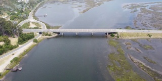 混凝土桥横跨河流，车辆在桥上行驶
