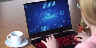 女商人在蓝色笔记本电脑屏幕上撰写金融和经济领域的数据评论。通过键盘操作4K分辨率视频的人。