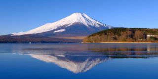 从冰冻的山中湖上倒立的富士山和蓝天