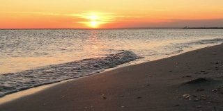 日落时平静的大海。夏日的黄昏海滨
