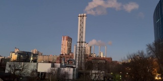 晚上基辅城市的工业景观。蒸汽烟从巨大的管道中冒出来。供热站为邻近的工业设施和住宅提供电力和热量。