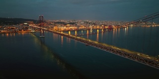 里斯本的汽车桥。城市大桥上的汽车通行。里斯本附近横跨大西洋的大桥。夜晚的城市灯光围绕着海湾。晚上里斯本。葡萄牙的夜城。日落之后的城市风光。