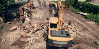 拆除建筑物。挖掘机拆旧房子，鸟瞰图