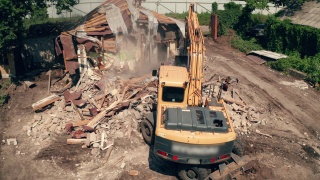 拆除建筑物。挖掘机拆旧房子，鸟瞰图视频素材模板下载