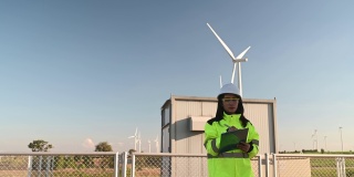 在风力发电厂工作的女工程师的剪影