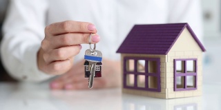 房地产经纪人展示房屋模型和钥匙