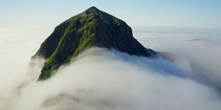 空中的全景。高高的绿峰上面密集的白云环绕着