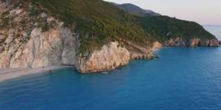 从空中俯瞰希腊爱奥尼亚岛美丽的米洛斯海滩和Lefkada悬崖。夕阳金色的阳光和蓝绿色的海湾