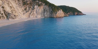 从空中俯瞰希腊爱奥尼亚岛美丽的米洛斯海滩和Lefkada悬崖。夕阳金色的阳光和蓝绿色的海湾