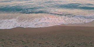 希腊爱奥尼亚岛莱夫卡达美丽的米洛斯海滩的低空鸟瞰图。夕阳金色的阳光和原始的海浪打破了蓝绿色的大海在岸边