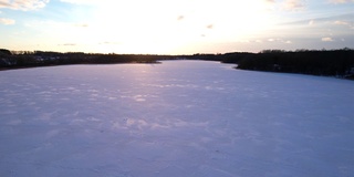 在冬季鸟瞰森林中冰冻的湖泊。冰天雪地的湖面在阳光的映衬下。