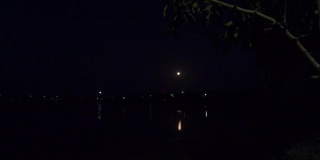 4K视频湖的满月和它的倒影在夜间。任何沿海地区或假期旅行背景。