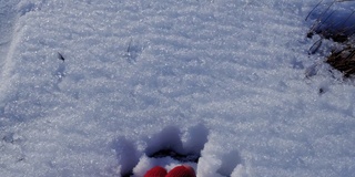 男人戴着红色手套的手在冬天的时候砸雪