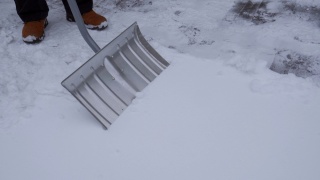 一个人正在用铲雪铲雪，清理道路。视频素材模板下载