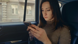女性在车内使用手机短信滚动浏览互联网搜索新闻视频素材模板下载
