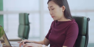 亚洲中国美女在办公室用笔记本电脑打字