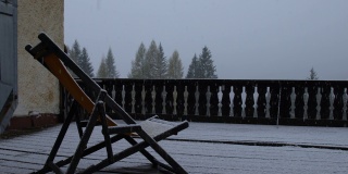 冬天的景观露台木房子和木椅在大雪期间，大雪落在一个郊区社区