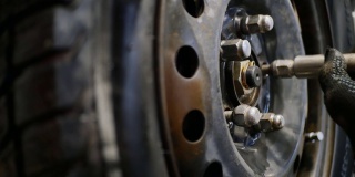 汽车修理工用气动扳手拧紧车轮上的螺母