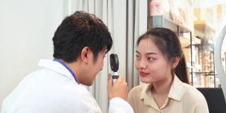 验光师调整视网膜镜和主观折射的距离，测试亚洲年轻女性的视力，准备配眼镜，表达积极的情绪，微笑以获得更好的视力