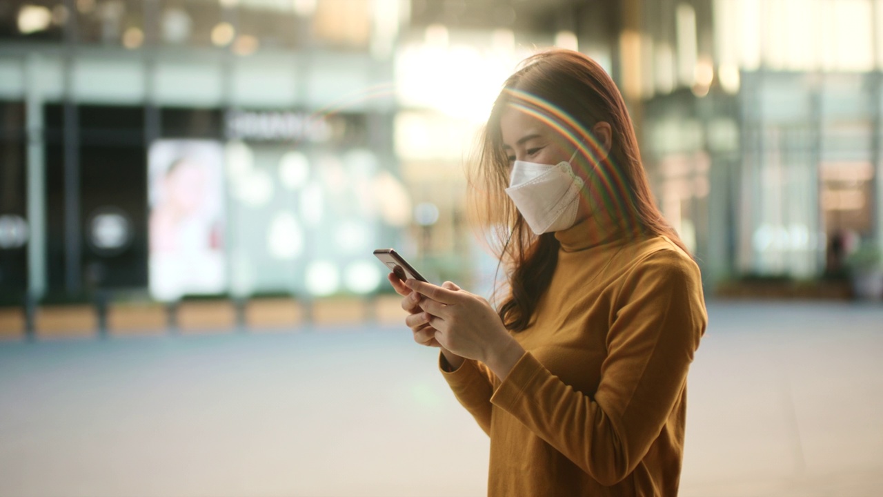 女子用智能手机防病毒口罩