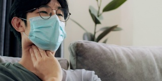 冠状病毒、covid-19和隔离的亚洲病人戴着防护口罩，喉咙痛和咳嗽。社会距离