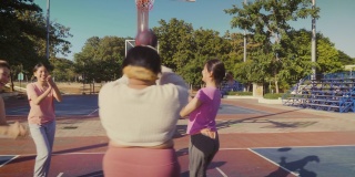 一小群年轻的亚洲女性朋友喜欢在户外打篮球