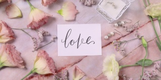 爱情卡片在大理石桌子上近粉红色的花俯视图放大
