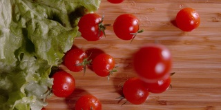 从上到下:拍下湿西红柿在台面上落下和滚动的电影镜头