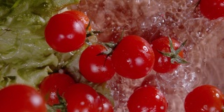 从上到下:鲜红的圣女果落在铺满水的切菜板上。