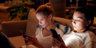 女性朋友使用智能手机。下午在沙发上放松，专注于屏幕