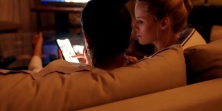 女性朋友使用智能手机。下午在沙发上放松，专注于屏幕