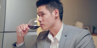 亚洲年轻情侣共进晚餐庆祝情人节。迷人的新婚男女享受夜晚的派对，在结婚纪念日喝一杯红酒，幸福的在家。