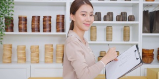 亚洲女商人肖像检查花瓶订单和看相机。年轻有吸引力的商业女孩工作准备包裹盒子检查电子商务航运在线零售销售在家里的商店。