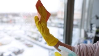 清洁工在手套上用喷雾和抹布清洗窗户，特写4k电影视频素材模板下载